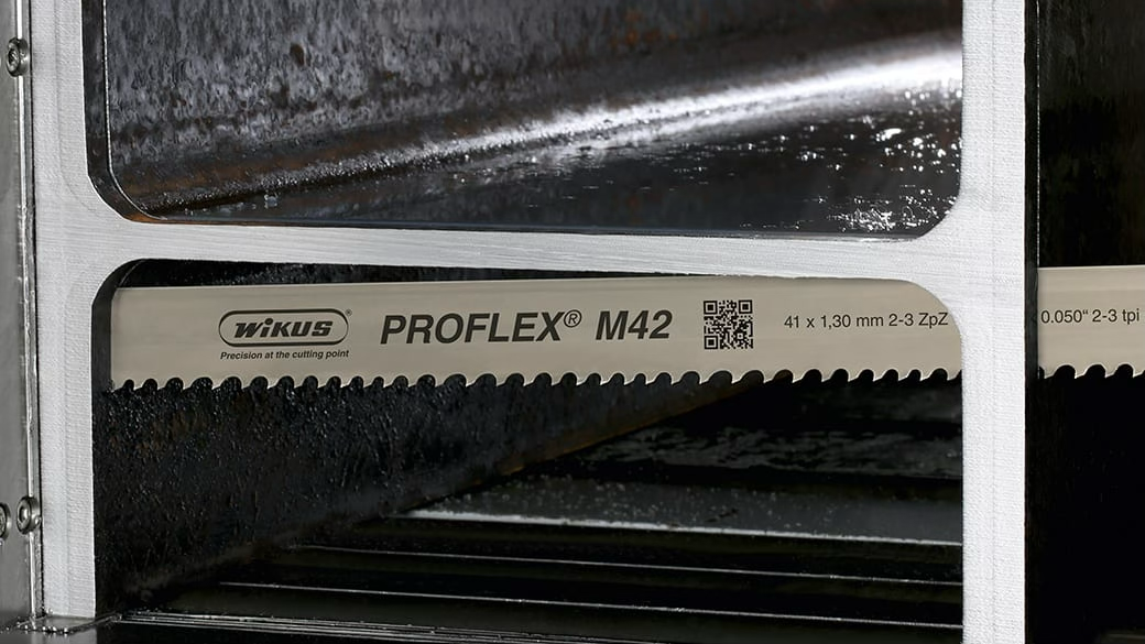 WIKUS PROFLEX M42 band saw blade mounted in a saw, cutting a bundle of steel sections.
